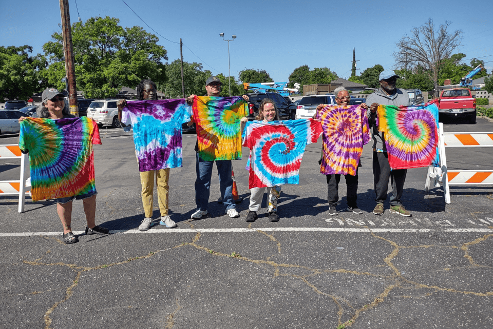 students holding up their tie dye projects