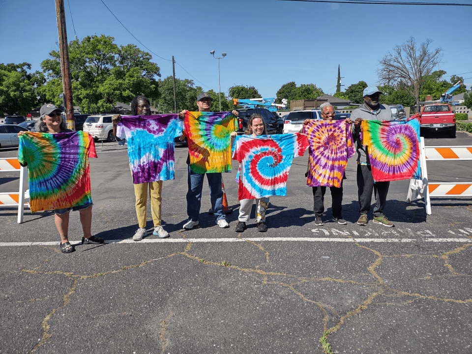 students holding up their tie dye projects