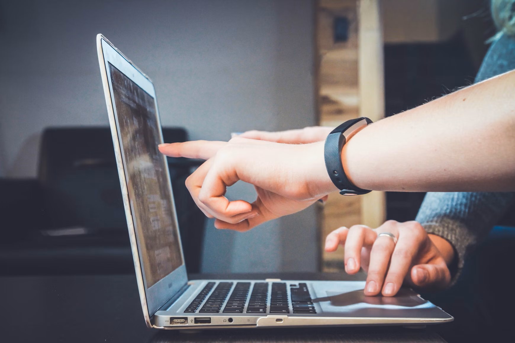 person pointing to computer screen